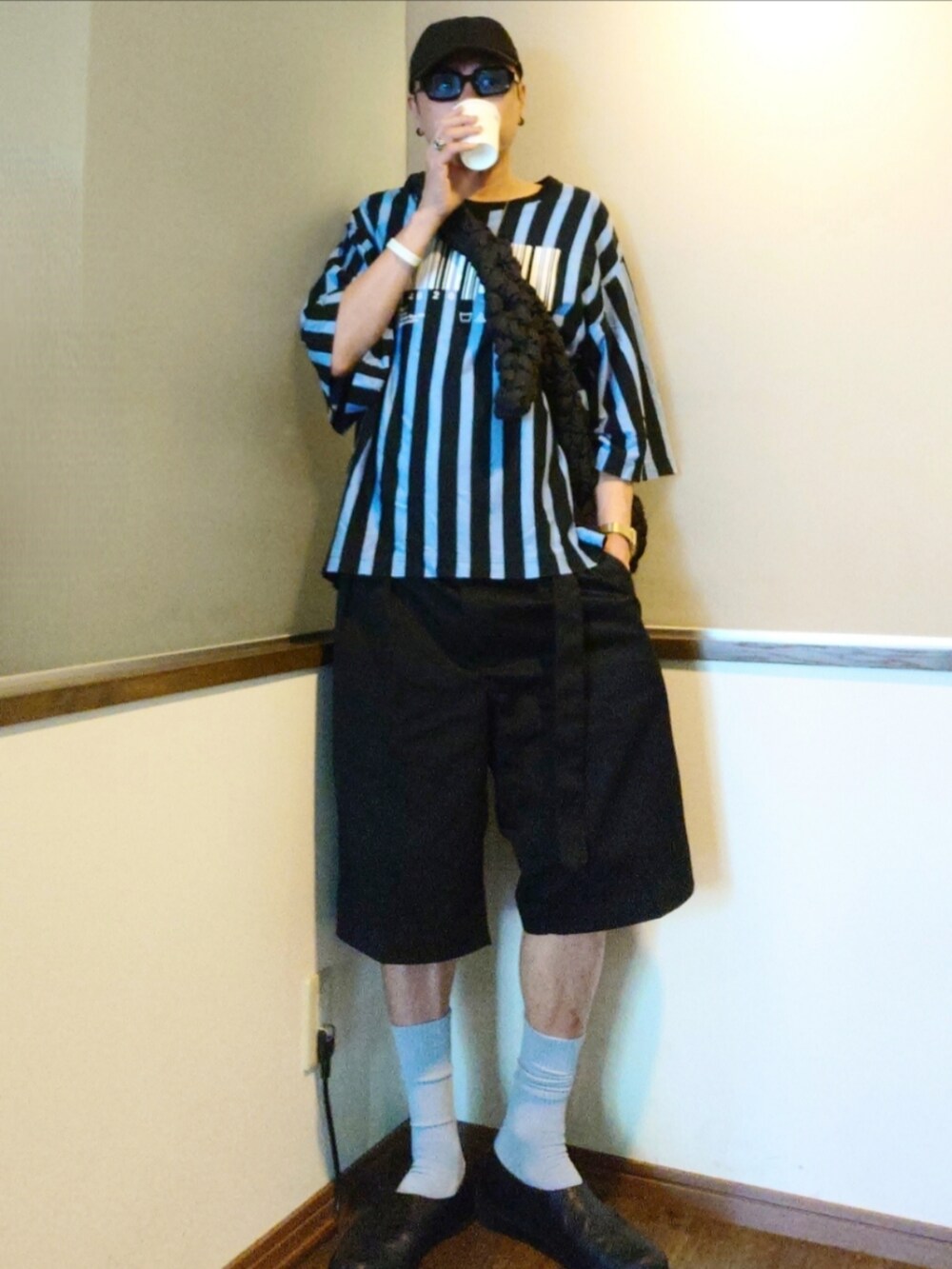 ブルー系のTシャツ/カットソー、ブラック系のショルダーバッグ、ブラック系のチノパンツを着用したメンズの夏コーディネートの2枚目の写真