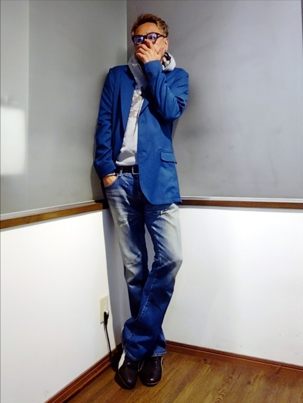 ブルー系のテーラードジャケット、グレー系のパーカー、ブルー系のデニムパンツを着用したメンズの秋コーディネートの2枚目の写真