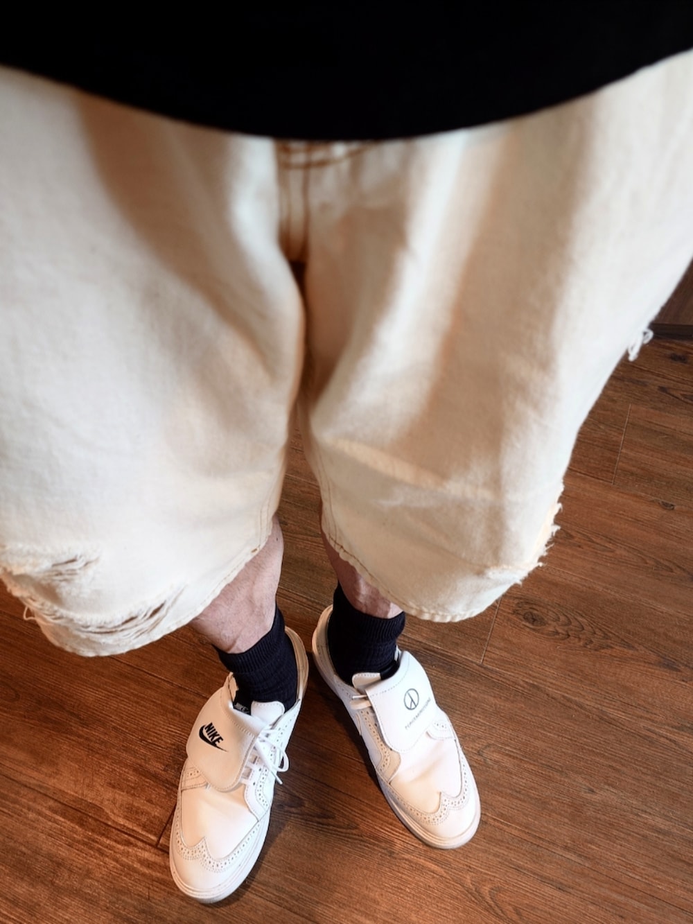 ブラック系のスウェット、ホワイト系のデニムパンツ、ブラック系のクラッチバッグを着用したメンズの夏コーディネートの4枚目の写真