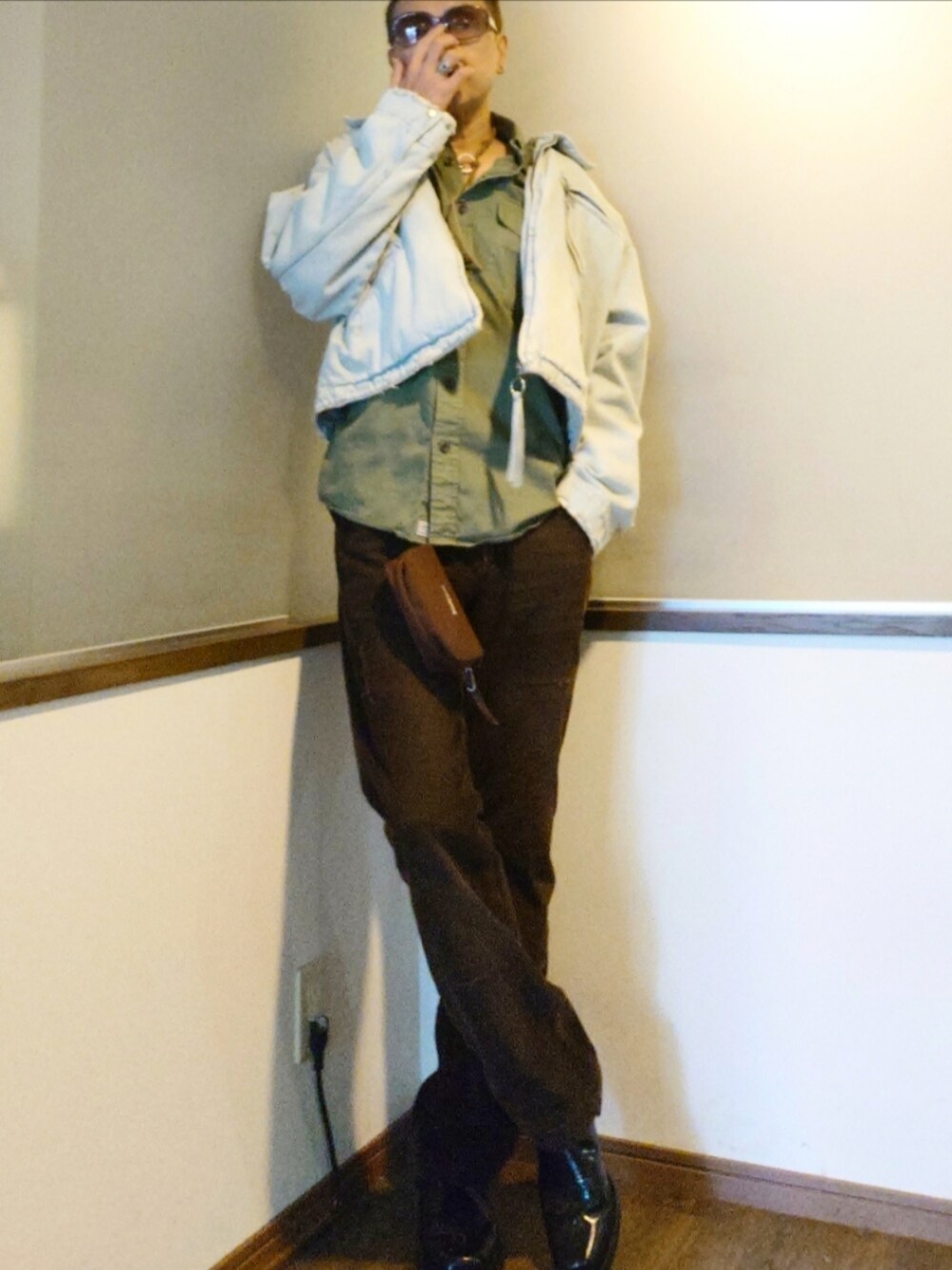 ブラウン系のパンツ、ブラック系のブーツ、グリーン系のシャツ/ブラウスを着用したメンズの秋コーディネートの2枚目の写真