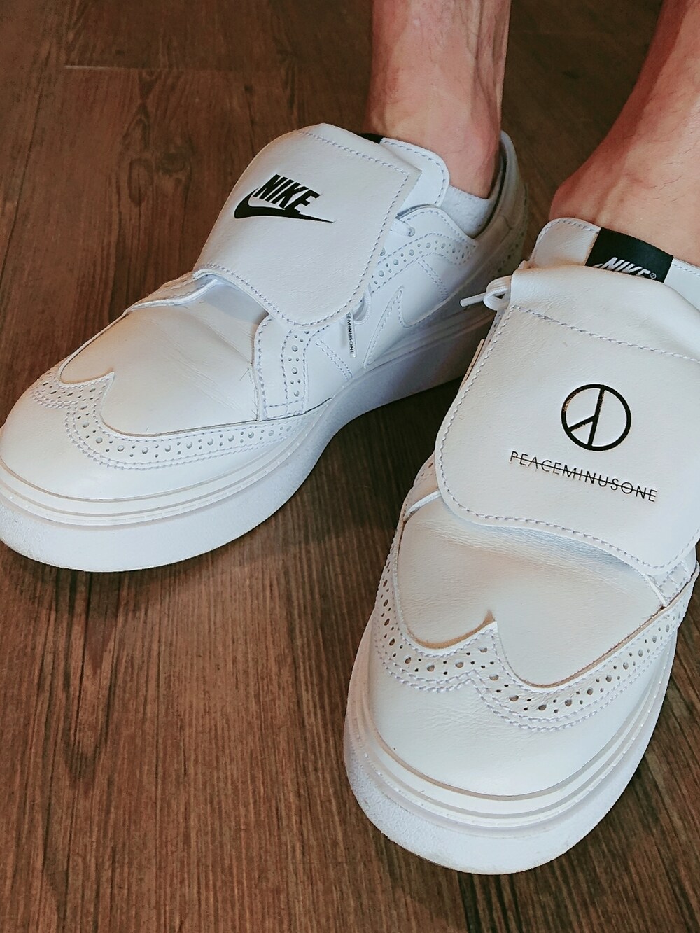 ブラック系のポロシャツ、ベージュ系のその他パンツ、ホワイト系のドレスシューズを着用したメンズの夏コーディネートの3枚目の写真