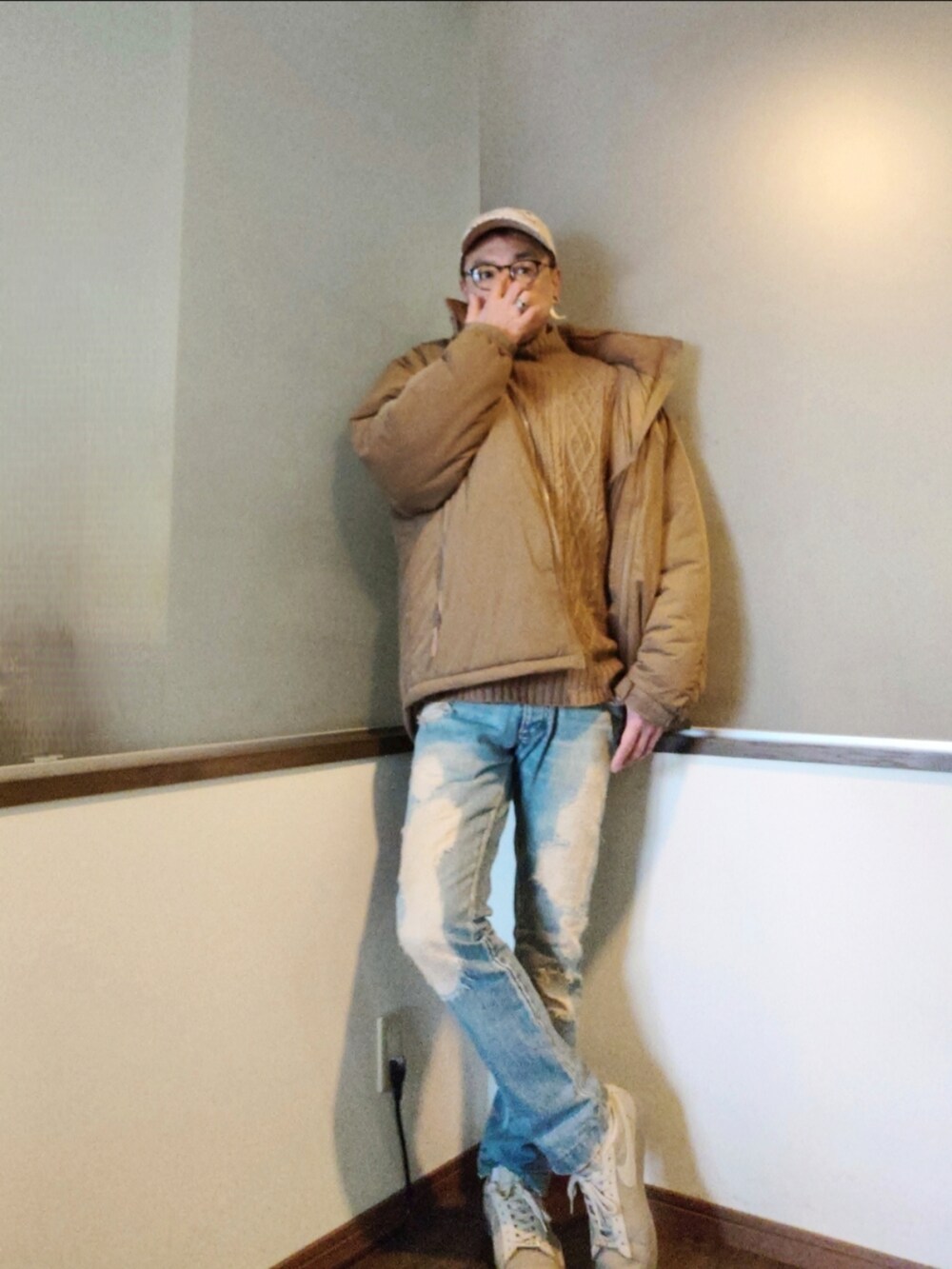 ベージュ系のダウンジャケット/コート、ブルー系のデニムパンツ、ベージュ系のスニーカーを着用したメンズの秋コーディネートの2枚目の写真