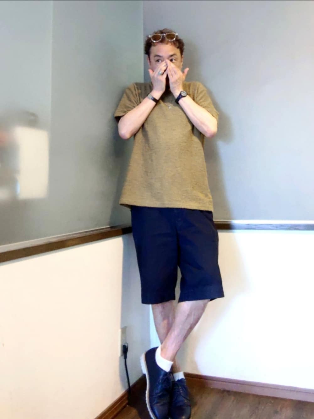グリーン系のニット/セーター、ブルー系のチノパンツ、ブルー系のブーツを着用したメンズの夏コーディネートの3枚目の写真