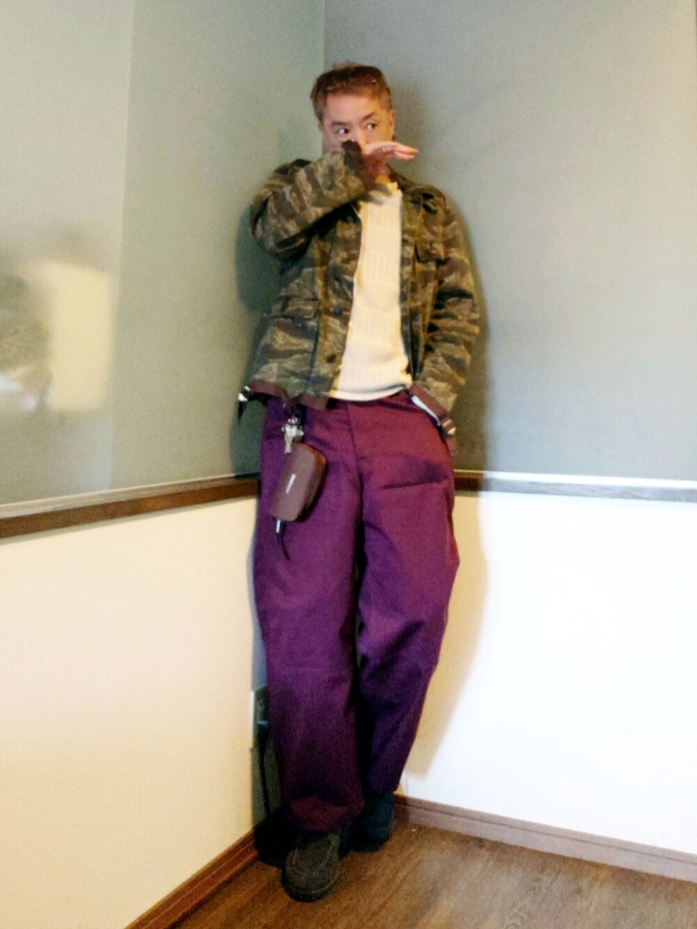 グリーン系のミリタリージャケット、ホワイト系のTシャツ/カットソー、レッド系のパンツを着用したメンズの春コーディネートの2枚目の写真