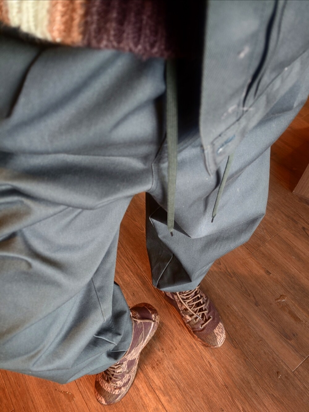 ベージュ系のダウンジャケット/コート、グリーン系のブルゾン、グリーン系のパンツを着用したメンズの冬コーディネートの2枚目の写真