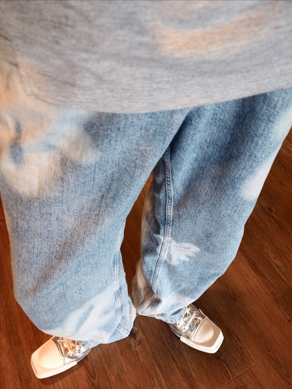 グレー系のTシャツ/カットソー、ブルー系のデニムパンツ、シルバー系のスニーカーを着用したメンズの夏コーディネートの2枚目の写真