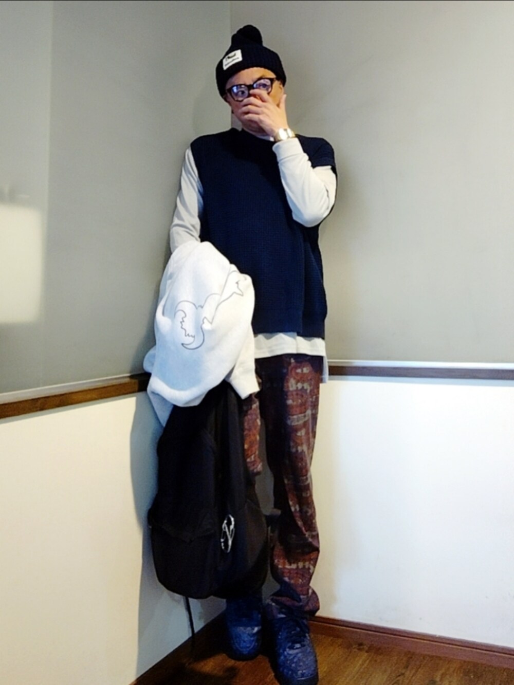 グレー系のパーカー、レッド系のパンツ、ブルー系のスニーカーを着用したメンズの秋コーディネートの4枚目の写真