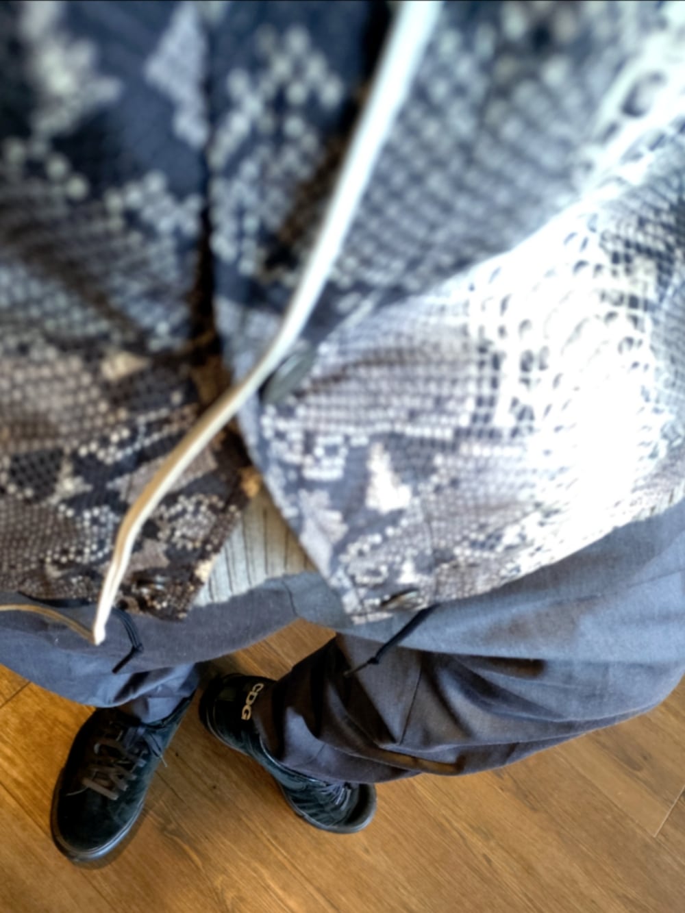 ホワイト系のナイロンジャケット、グレー系のスラックス、ブラック系のスニーカーを着用したメンズの秋コーディネートの4枚目の写真