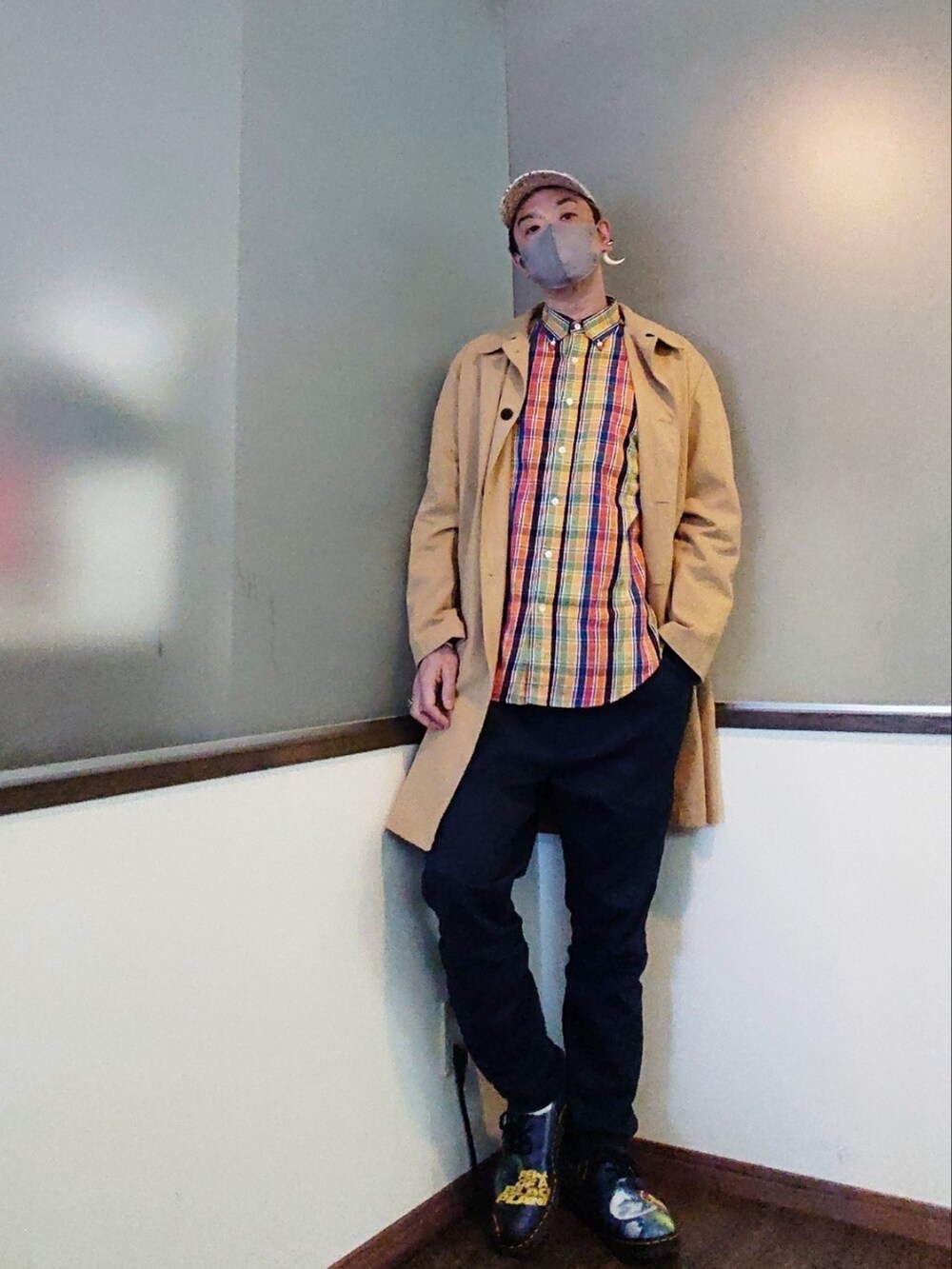 ベージュ系のステンカラーコート、イエロー系のシャツ/ブラウス、ブルー系のパンツを着用したメンズの春コーディネートの4枚目の写真