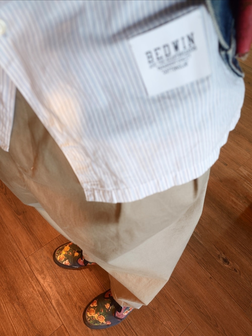 ブルー系のデニムジャケット、ピンク系のメッセンジャーバッグ、ホワイト系のシャツ/ブラウスを着用したメンズの秋コーディネートの3枚目の写真