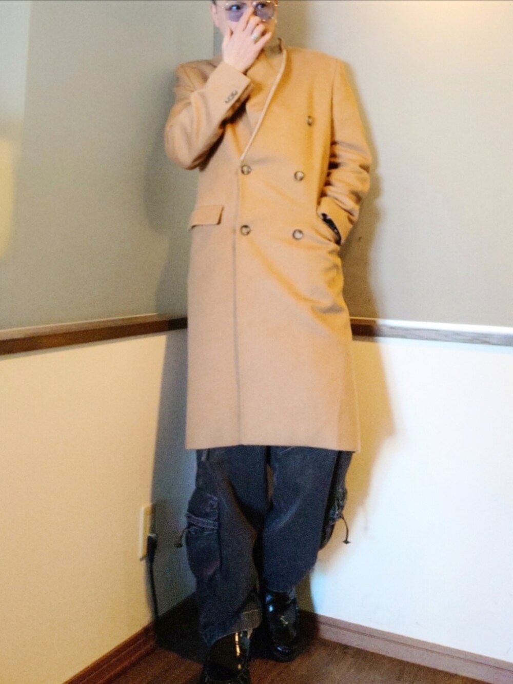 ベージュ系のチェスターコート、グレー系のニット/セーター、ブラック系のカーゴパンツを着用したメンズの冬コーディネートの2枚目の写真