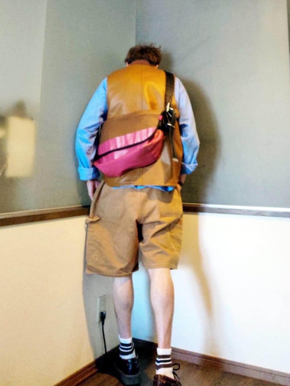 ブラウン系のダウンベスト、ブラウン系のパンツ、ブラウン系のモカシン/デッキシューズを着用したメンズの春コーディネートの3枚目の写真