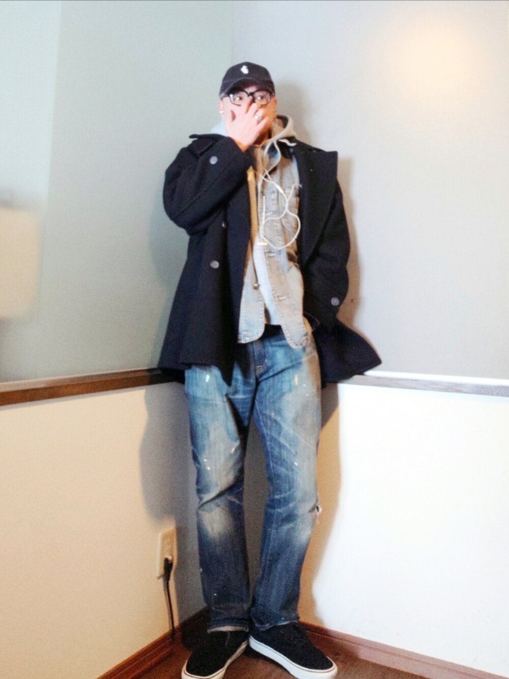 ブラック系のピーコート、ブルー系のカバーオール、グレー系のパーカーを着用したメンズの冬コーディネートの2枚目の写真