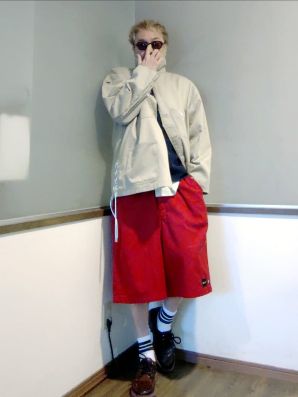 ベージュ系のカバーオール、レッド系のチノパンツ、ブラウン系のモカシン/デッキシューズを着用したメンズの春コーディネートの2枚目の写真