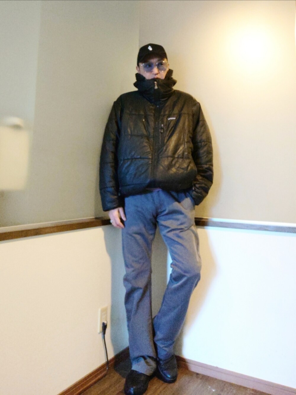 ブラック系のダウンジャケット/コート、グレー系のチノパンツ、パープル系のニット/セーターを着用したメンズの秋コーディネートの2枚目の写真