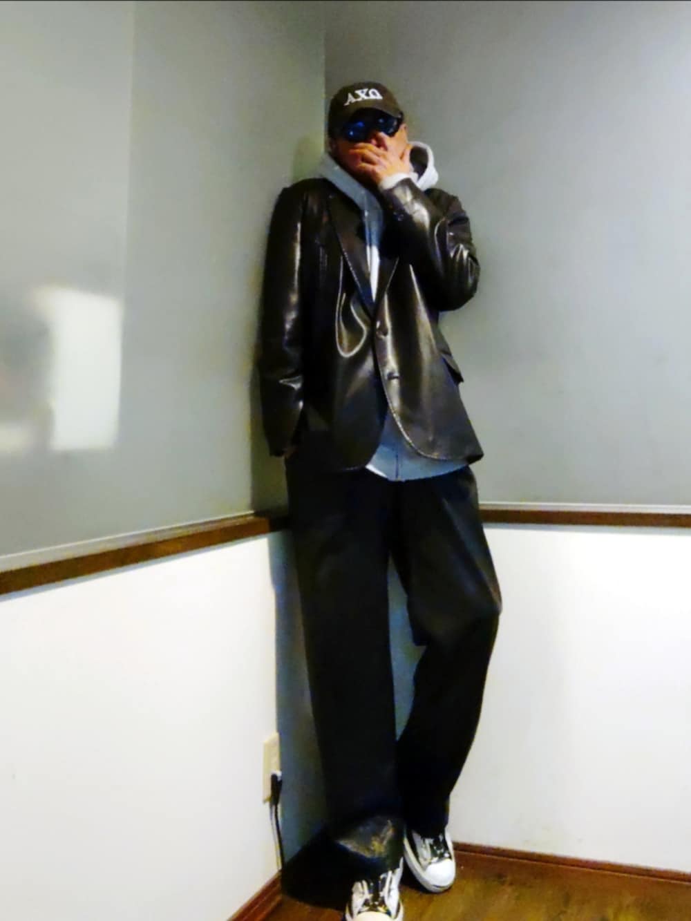 ブラック系のテーラードジャケット、グレー系のパーカー、ブラック系のその他パンツを着用したメンズの春コーディネートの3枚目の写真