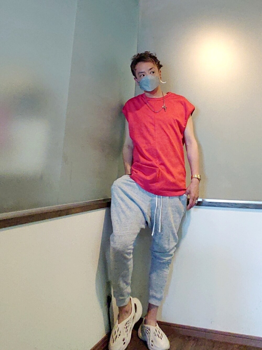 レッド系のTシャツ/カットソー、グレー系のスウェットパンツ、ホワイト系のスニーカーを着用したメンズの夏コーディネートの3枚目の写真