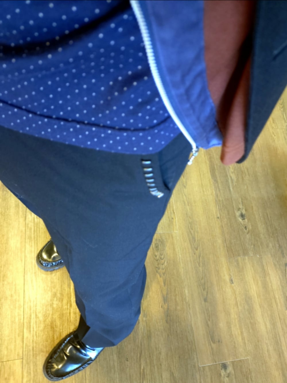 グレー系のテーラードジャケット、ブラウン系のカーディガン/ボレロ、ブラック系のスラックスを着用したメンズの秋コーディネートの4枚目の写真