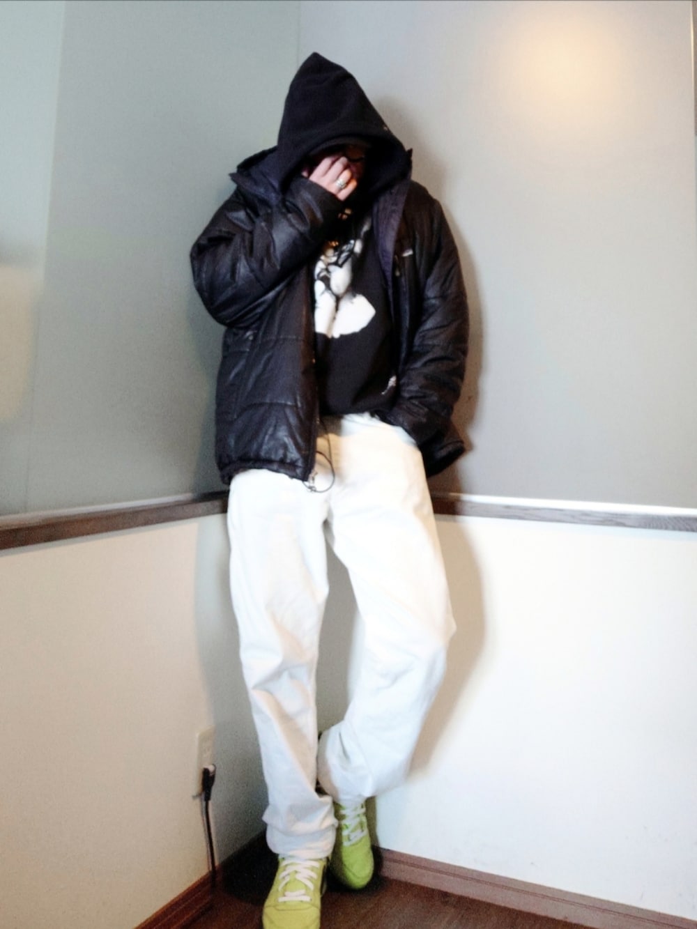 ブラック系のダウンジャケット/コート、ブラック系のスウェット、ホワイト系のデニムパンツを着用したメンズの春コーディネートの2枚目の写真