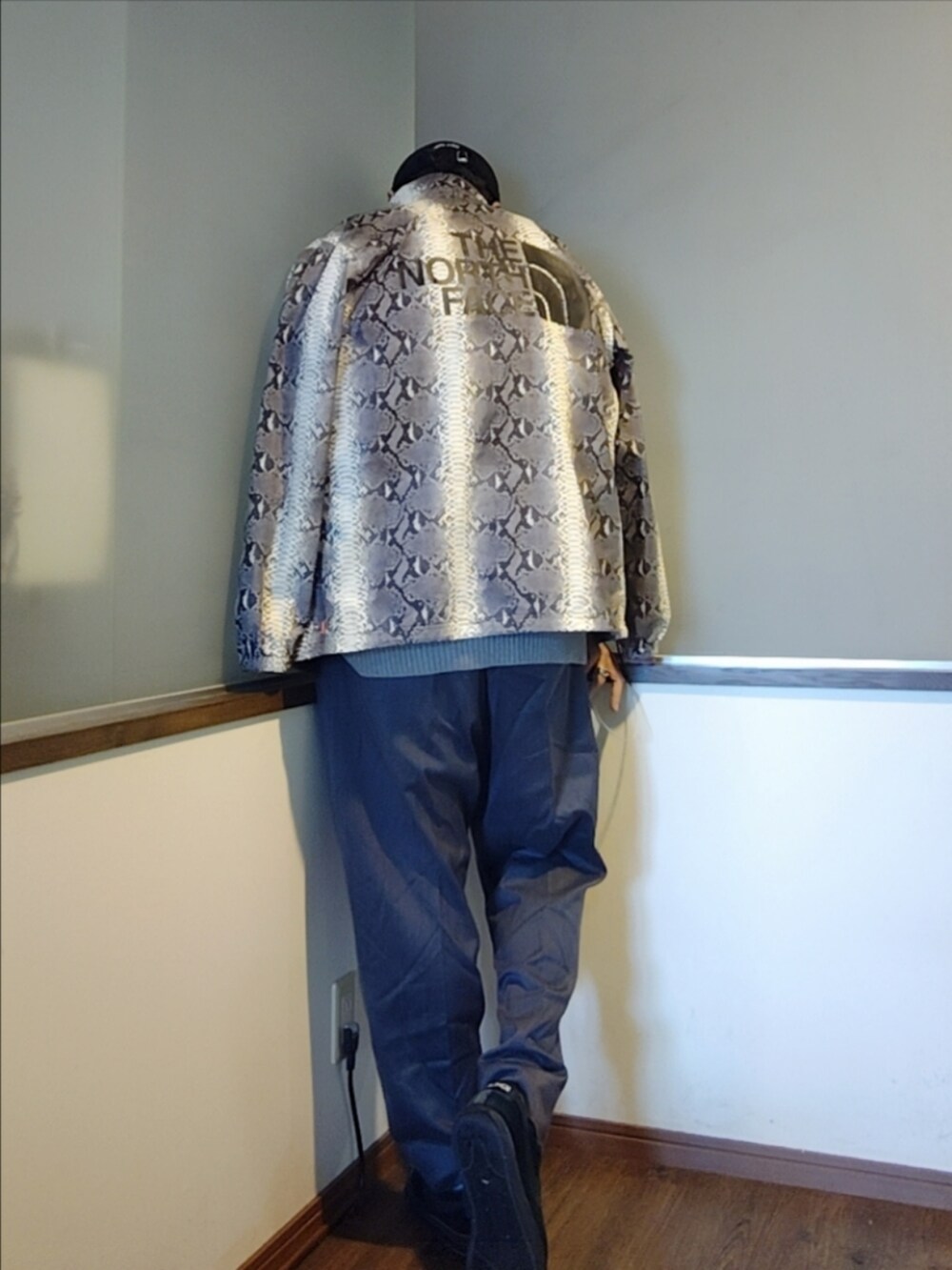 ホワイト系のナイロンジャケット、グレー系のスラックス、ブラック系のスニーカーを着用したメンズの秋コーディネートの3枚目の写真