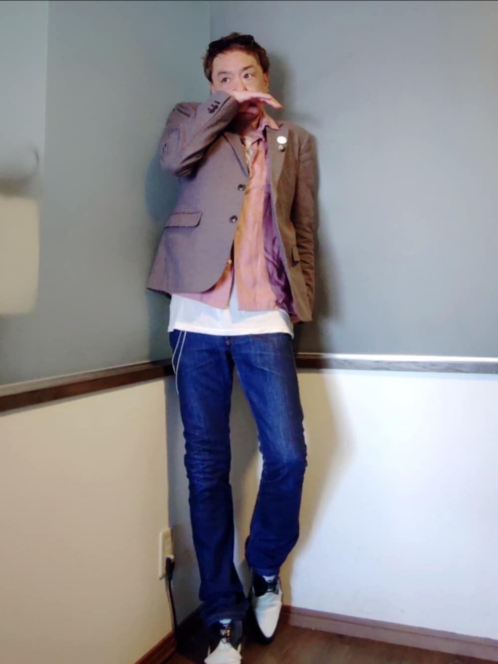 ブルー系のデニムパンツ、ホワイト系のドレスシューズ、その他のテーラードジャケットを着用したメンズの春コーディネートの2枚目の写真