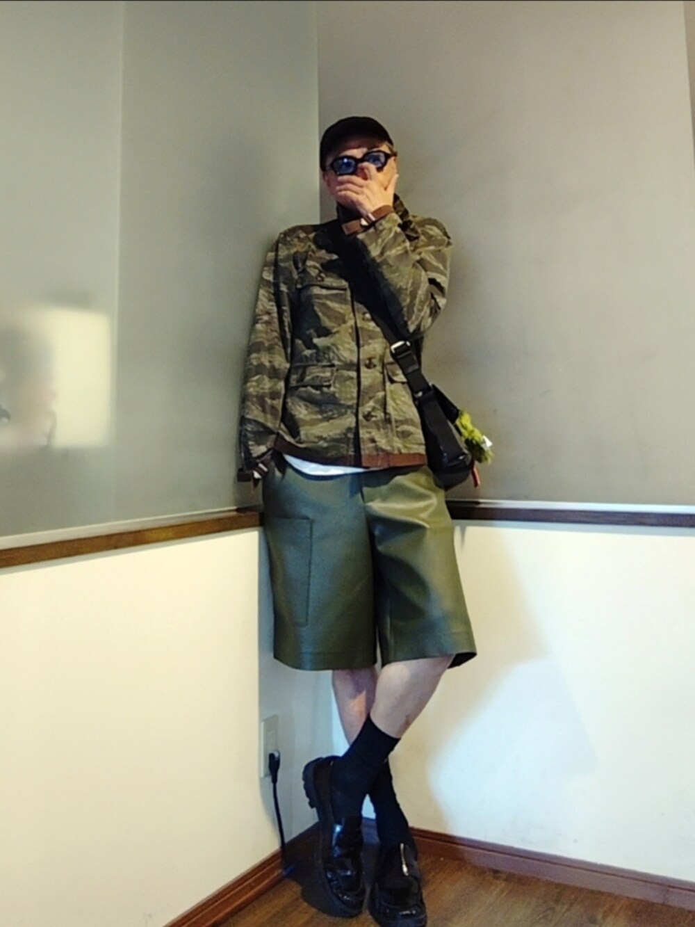 グリーン系のミリタリージャケット、ブラック系のショルダーバッグ、グリーン系のその他パンツを着用したメンズの秋コーディネートの2枚目の写真