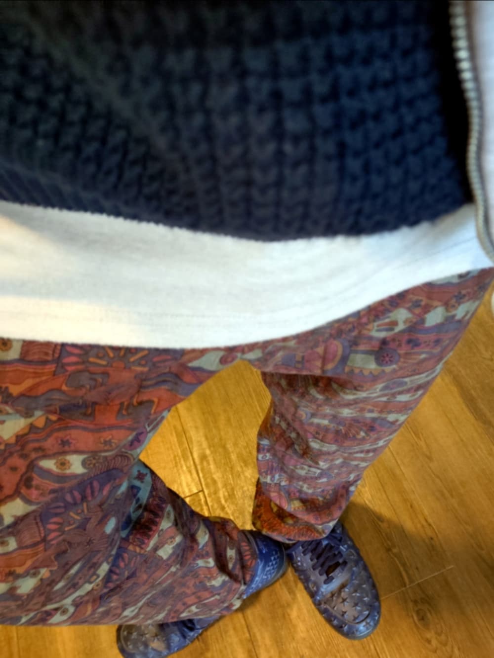 グレー系のパーカー、レッド系のパンツ、ブルー系のスニーカーを着用したメンズの秋コーディネートの5枚目の写真