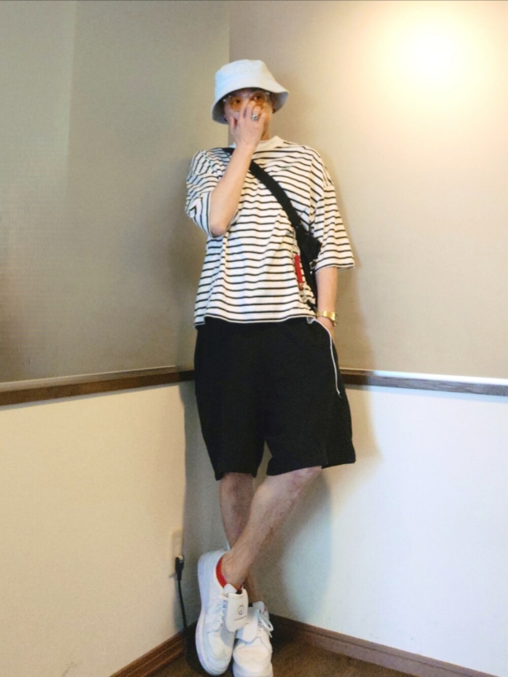 ホワイト系のTシャツ/カットソー、ホワイト系のショルダーバッグ、ブラック系のスウェットパンツを着用したメンズの夏コーディネートの2枚目の写真