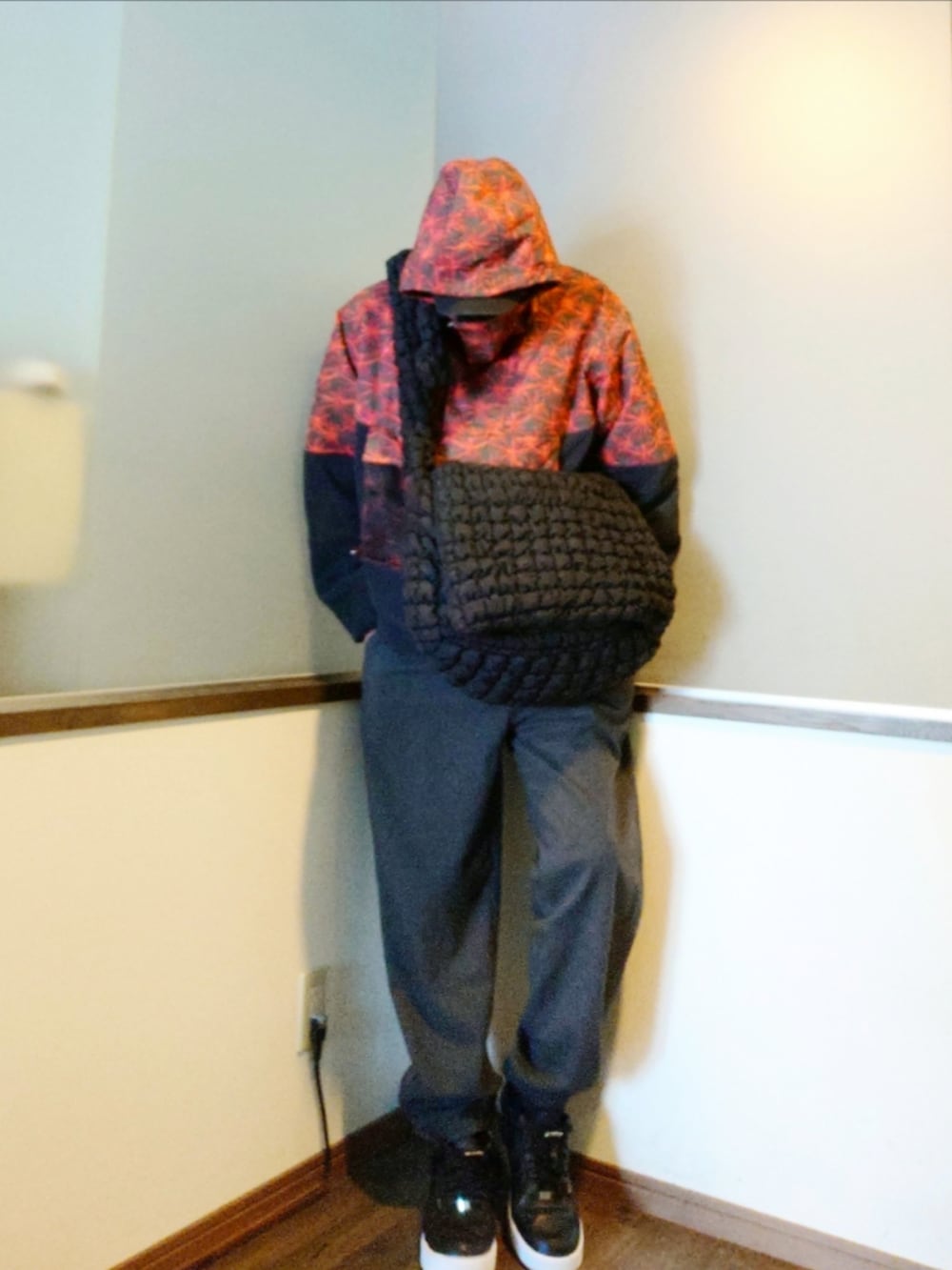 レッド系のブルゾン、グレー系のその他パンツ、ブラック系のスニーカーを着用したメンズの冬コーディネートの2枚目の写真