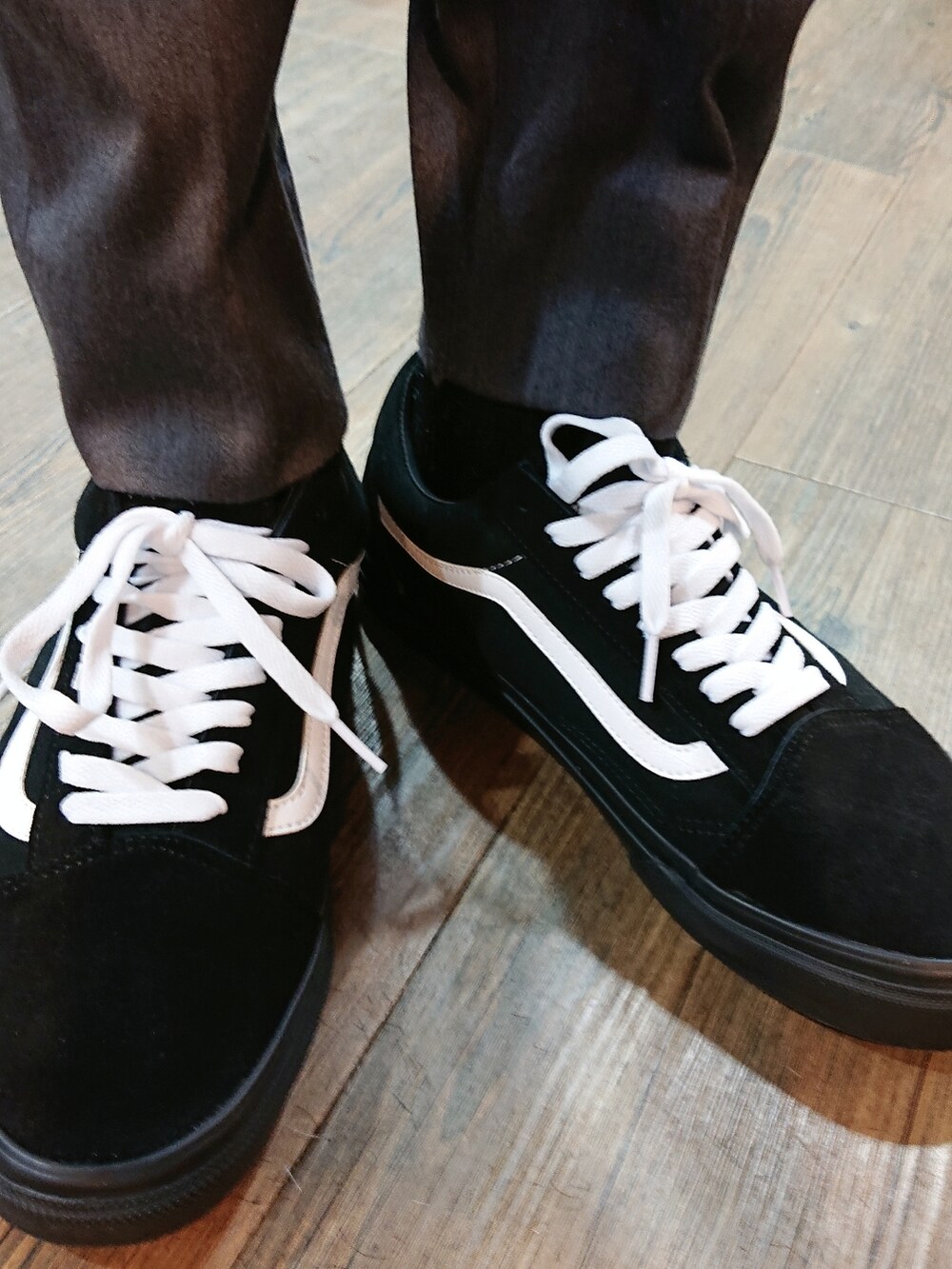 ホワイト系のシャツ/ブラウス、グレー系のスラックス、ブラック系のスニーカーを着用したメンズの夏コーディネートの3枚目の写真