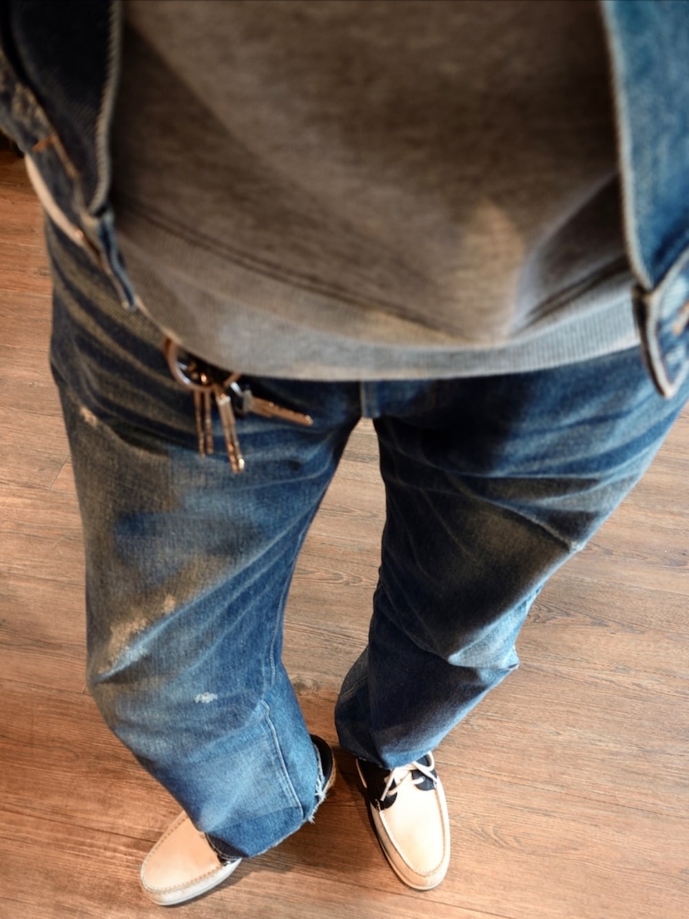 グレー系のパーカー、ブルー系のデニムジャケット、ブルー系のデニムパンツを着用したメンズの秋コーディネートの3枚目の写真