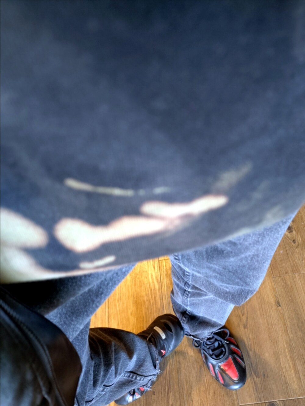 ブラック系のパーカー、ブラック系のデニムパンツ、ブラック系のスニーカーを着用したメンズの秋コーディネートの2枚目の写真