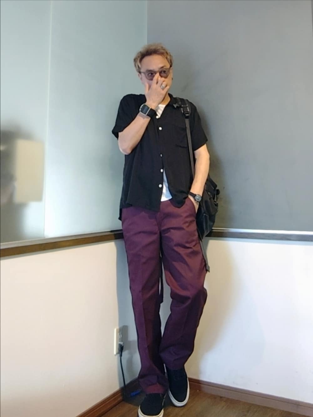 レッド系のチノパンツ、ブラック系のスニーカー、ブラック系のバックパック/リュックを着用したメンズの夏コーディネートの2枚目の写真