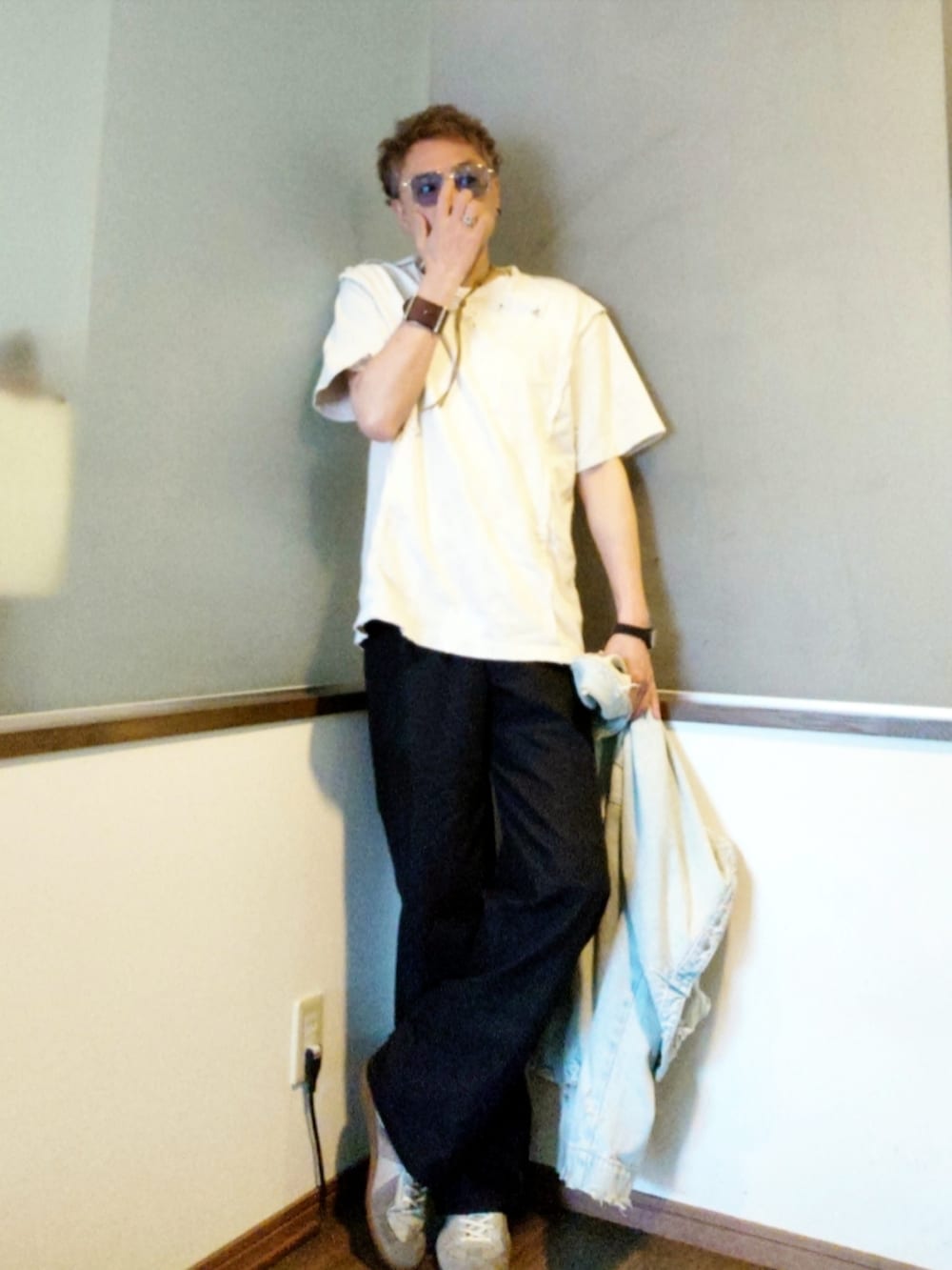 ホワイト系のTシャツ/カットソー、ブルー系のデニムジャケット、ブラック系のスラックスを着用したメンズの春コーディネートの2枚目の写真