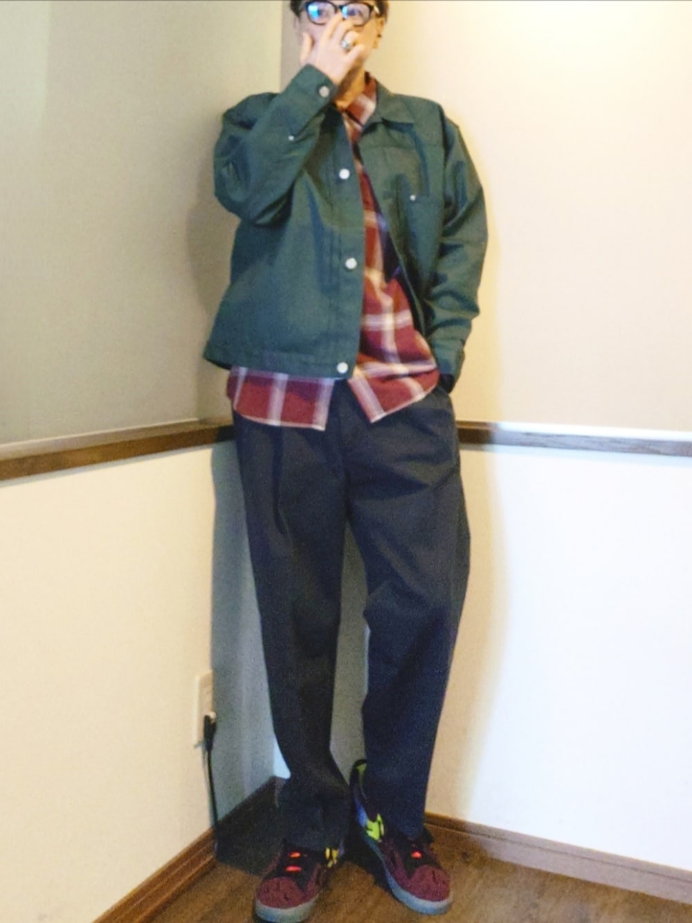 グリーン系のブルゾン、グレー系のスラックス、レッド系のスニーカーを着用したメンズの夏コーディネートの2枚目の写真