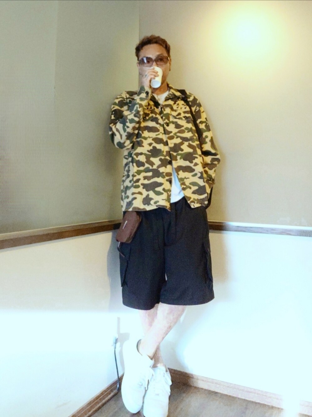 ブラウン系のシャツ/ブラウス、ブラック系のカーゴパンツ、ホワイト系のスニーカーを着用したメンズの夏コーディネートの2枚目の写真