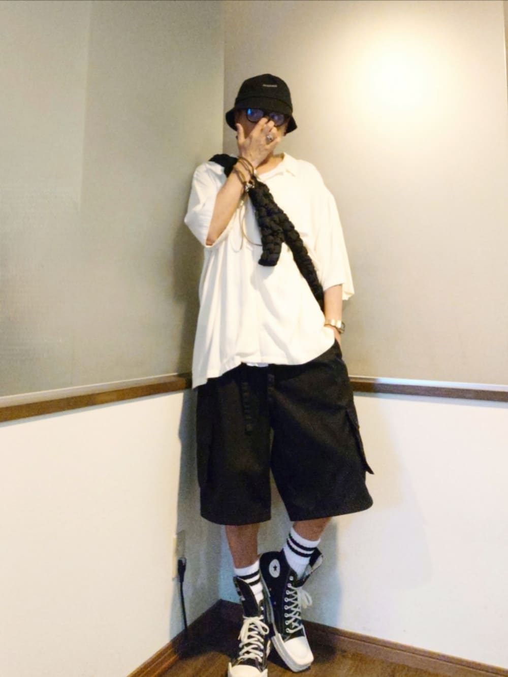 ブラック系のスニーカー、ブラック系のカーゴパンツ、ブラック系のショルダーバッグを着用したメンズの夏コーディネートの2枚目の写真