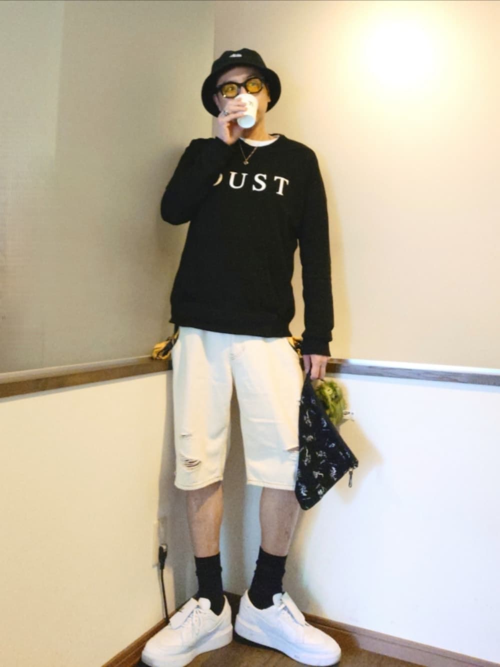 ブラック系のスウェット、ホワイト系のデニムパンツ、ブラック系のクラッチバッグを着用したメンズの夏コーディネートの3枚目の写真