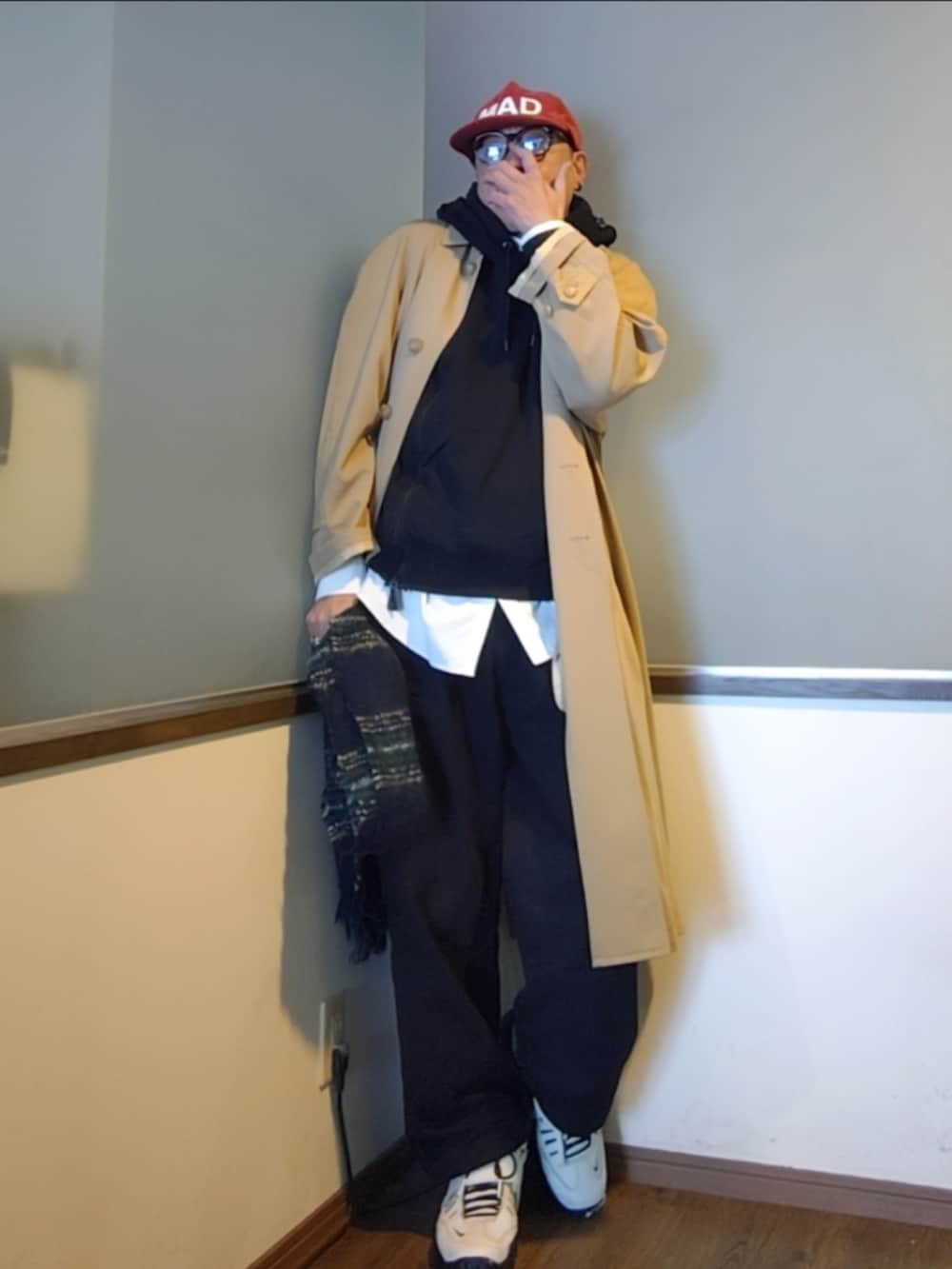 ベージュ系のトレンチコート、ブラック系のパーカー、ブラック系のその他パンツを着用したメンズの秋コーディネートの4枚目の写真