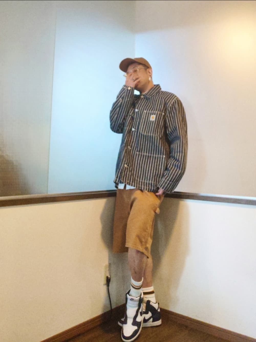 ブルー系のカバーオール、ブラウン系のパンツ、ホワイト系のスニーカーを着用したメンズの秋コーディネートの2枚目の写真