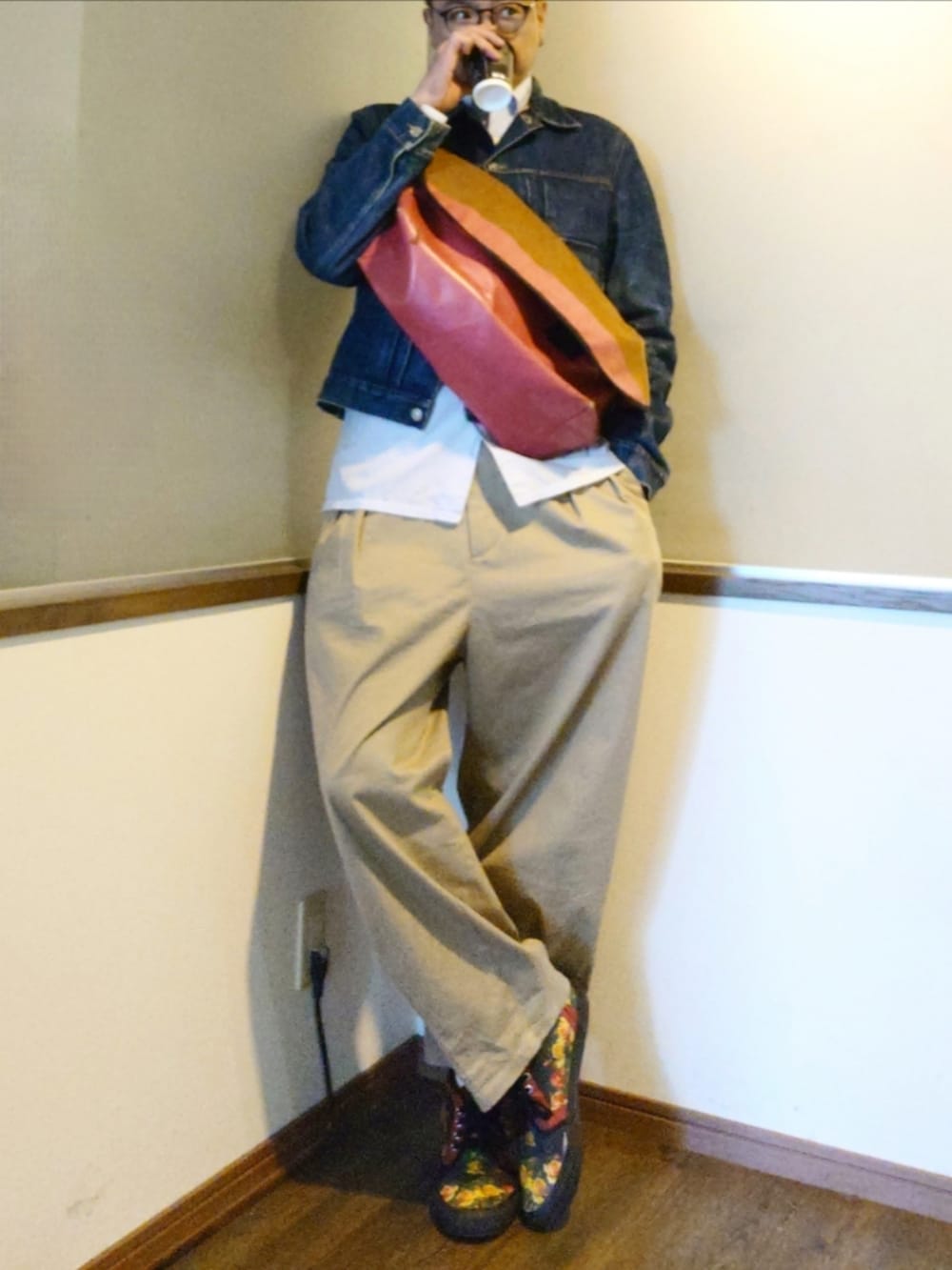 ブルー系のデニムジャケット、ピンク系のメッセンジャーバッグ、ホワイト系のシャツ/ブラウスを着用したメンズの秋コーディネートの2枚目の写真