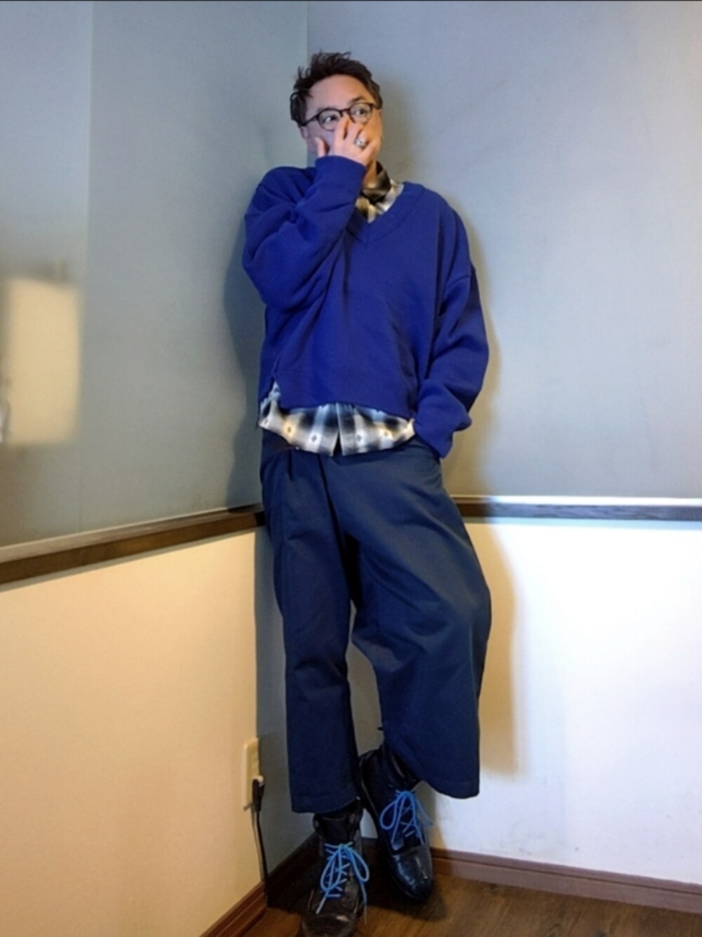 ブルー系のチノパンツ、ブルー系のニット/セーター、ブラック系のシャツ/ブラウスを着用したメンズの冬コーディネートの2枚目の写真