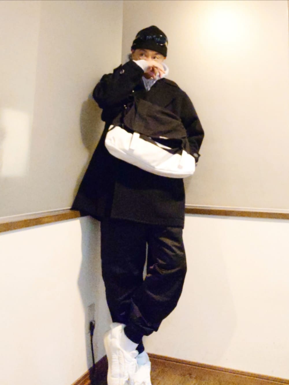 グレー系のパーカー、ブラック系のピーコート、ホワイト系のシャツ/ブラウスを着用したメンズの冬コーディネートの2枚目の写真