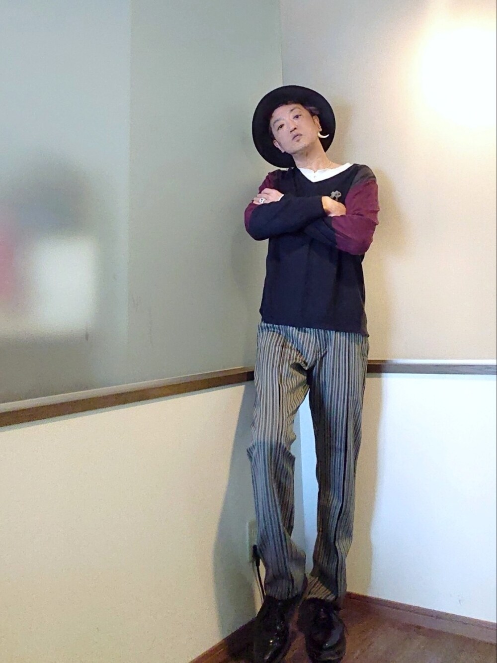 ブルー系のニット/セーター、グレー系のスラックス、ブラック系のドレスシューズを着用したメンズの春コーディネートの3枚目の写真