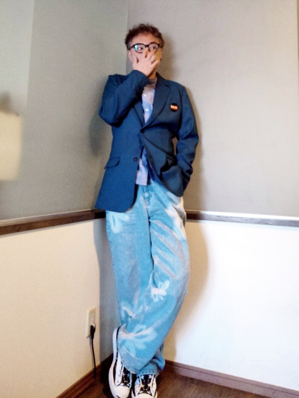 ブルー系のテーラードジャケット、ブルー系のデニムパンツ、ホワイト系のスニーカーを着用したメンズの春コーディネートの2枚目の写真