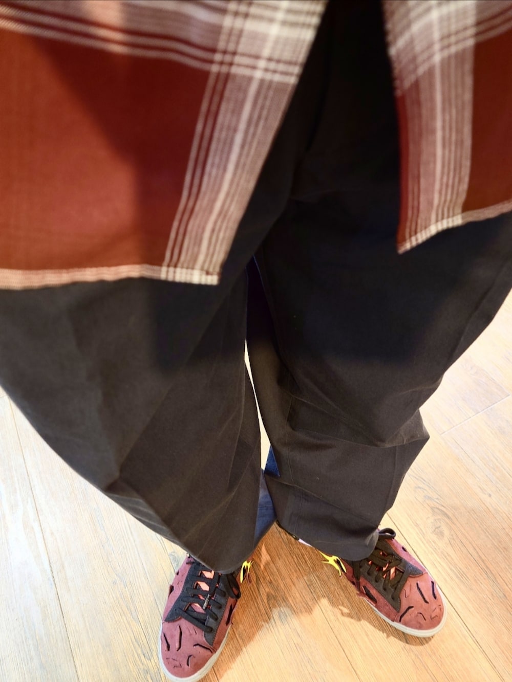 グリーン系のブルゾン、グレー系のスラックス、レッド系のスニーカーを着用したメンズの夏コーディネートの3枚目の写真