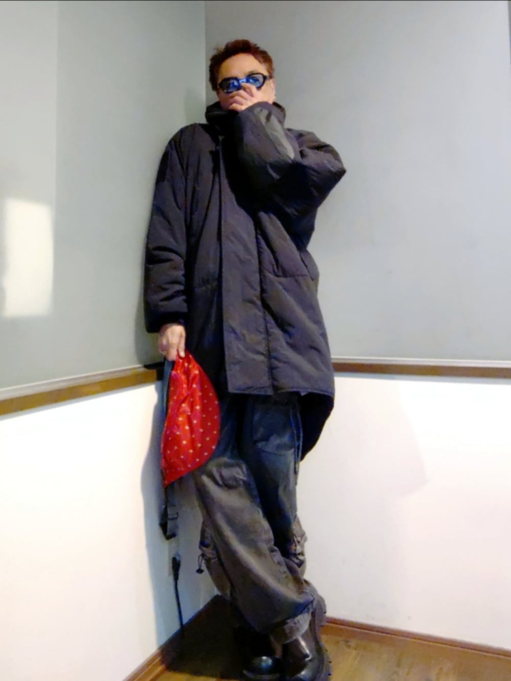 ブラック系のダウンジャケット/コート、ブラック系のジャージ、レッド系のショルダーバッグを着用したメンズの冬コーディネートの2枚目の写真