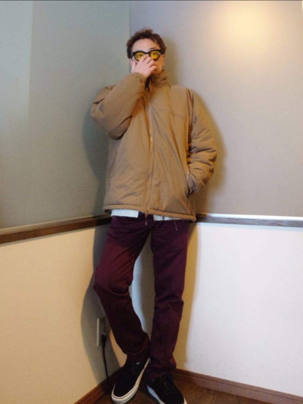 レッド系のカバーオール、ベージュ系のダウンジャケット/コート、レッド系のチノパンツを着用したメンズの冬コーディネートの2枚目の写真