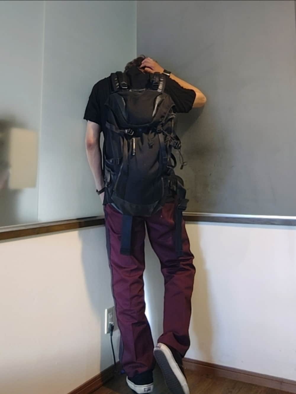 レッド系のチノパンツ、ブラック系のスニーカー、ブラック系のバックパック/リュックを着用したメンズの夏コーディネートの3枚目の写真