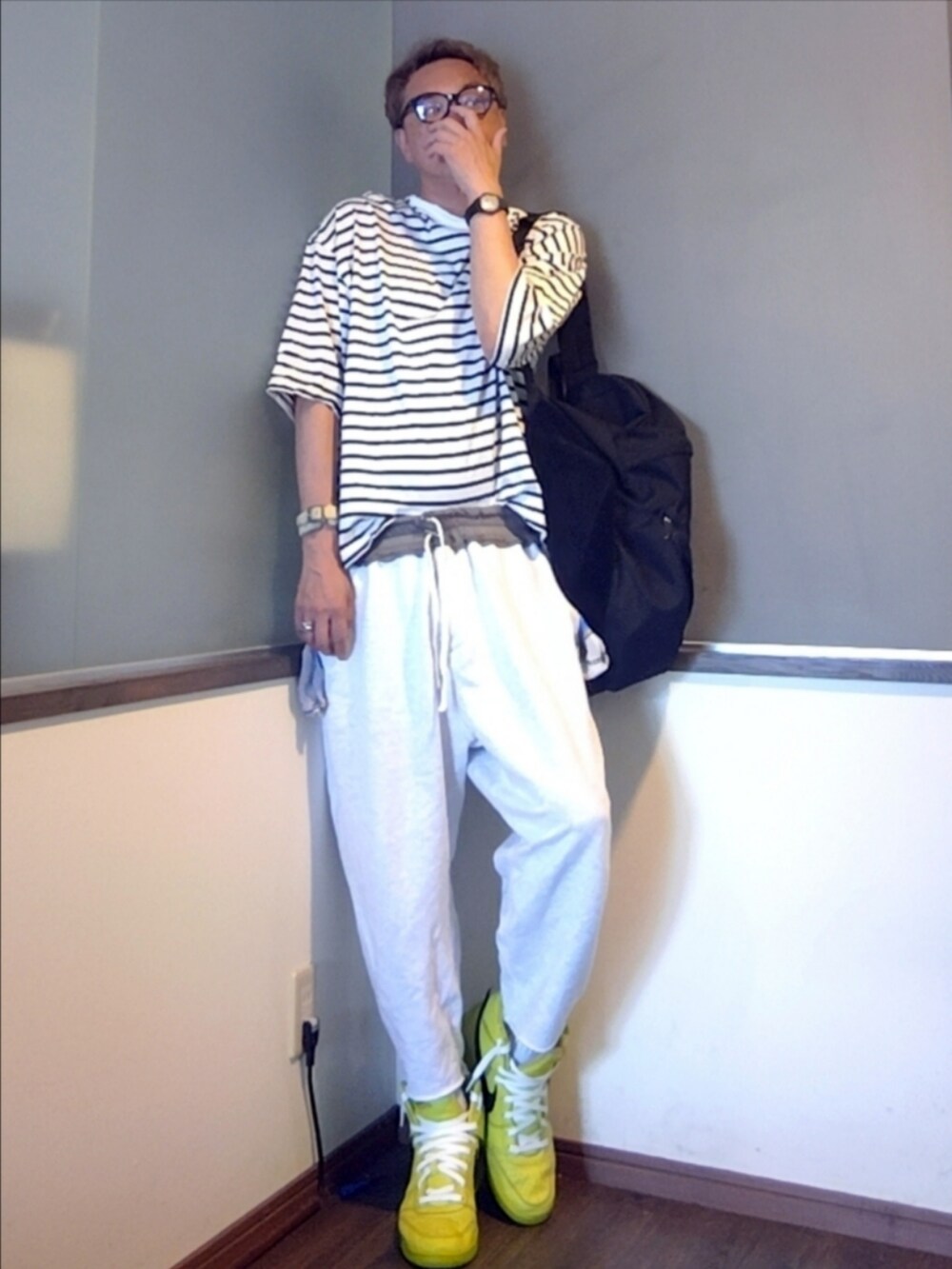 グリーン系のスニーカー、グレー系のスウェットパンツ、ブラック系のバックパック/リュックを着用したメンズの夏コーディネートの2枚目の写真